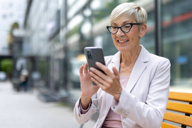 istock Older woman enjoying smartphone in urban setting 2195190725