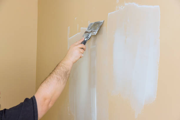 istock Preparing a wall for painting by applying drywall compound to smooth the surface inside a home 2195191758