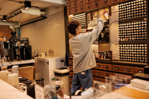 Male barista working in the bar at the coffee shop.