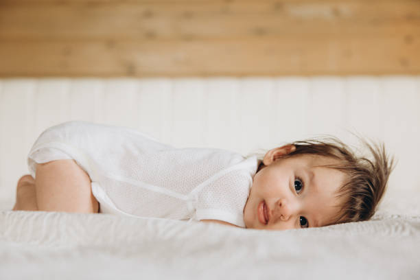 istock Baby plays on a soft bed in a cozy room with natural light 2195196836