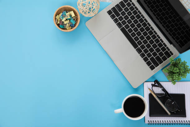 istock Top view desk office workspace and laptop and supply equipment with empty copy space for freelance working productive workplace area or home office flat lay background. 2195200091