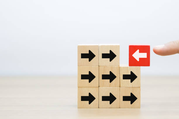 istock Hand chooses arrow icon point to the opposite side on wooden toy block stack for adaptation challenge change transformation business plan and choice the way forward goal to growth 2195200121