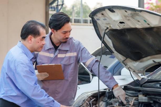 istock Mechanic explaining engine details to customer with precision and clarity during car inspection. Representing professional service and strong customer relationship in small auto repair businesses. 2195204387