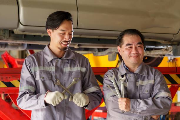 istock Mechanics holding tools confidently in automotive workshop, representing professionalism, experience, and trust in small business car repair services. 2195204458