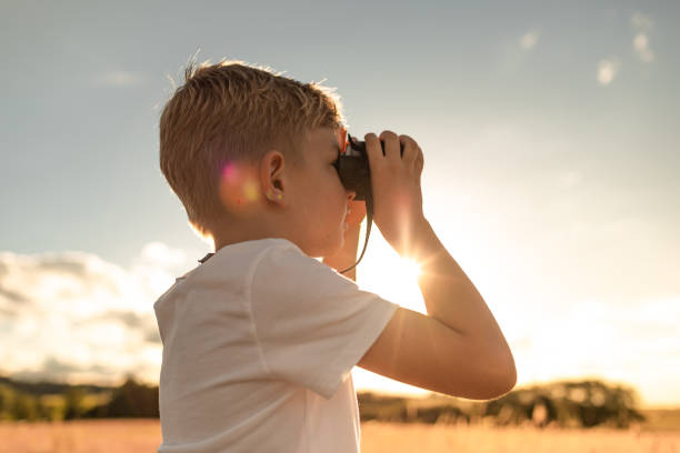istock Little boy using binoculars to look for a wildlife. Science, learning concept. 2195204729