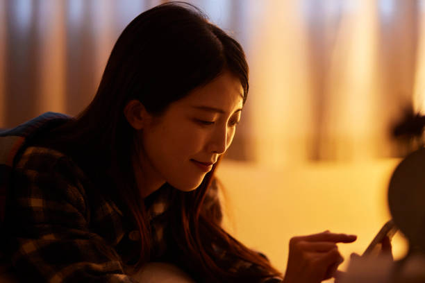Japanese woman using smartphone in bedroom at night