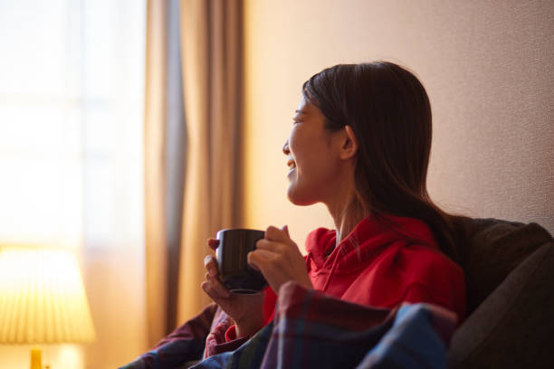 istock Japanese woman sitting on the sofa drinking coffee 2195205212