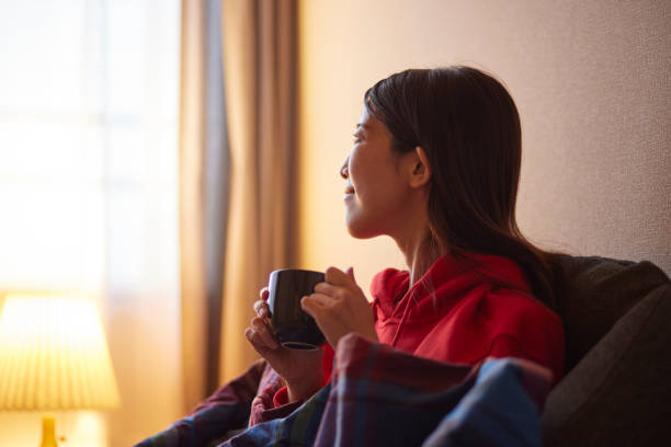 istock Japanese woman sitting on the sofa drinking coffee 2195205214