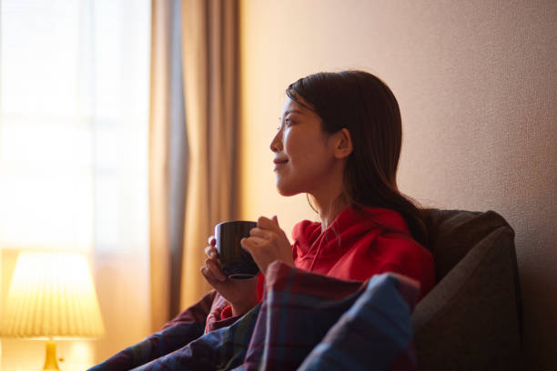istock Japanese woman sitting on the sofa drinking coffee 2195205261