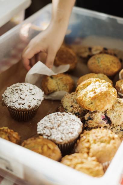 istock Hand selecting freshly baked muffins from a tray. 2195205393