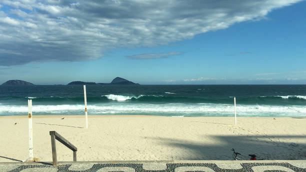 Top view of the beach with umbrellas and unidentified sunbathers in a green sea. Canasvieras Beach - Florianópolis