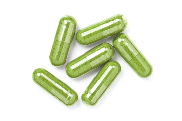 istock Green herbal powder medicine capsules pill 2195208872