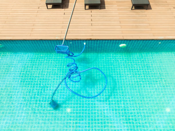istock Pool maintenance with scoop net  and automatic robot cleaner. 2195209411