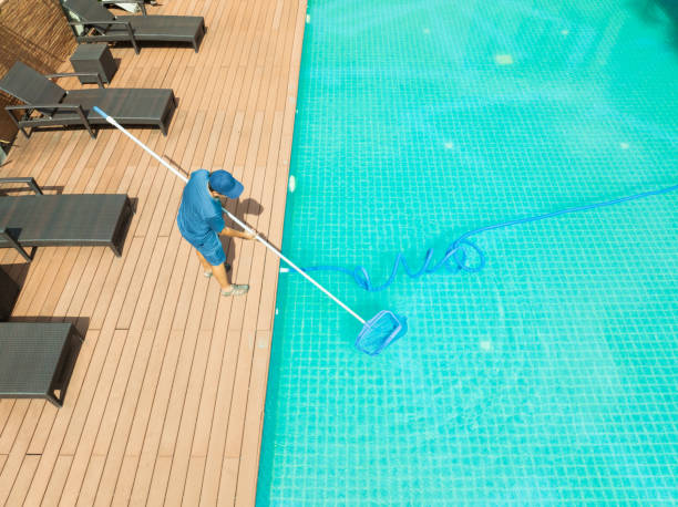istock Pool maintenance with scoop net  and automatic robot cleaner. 2195209420