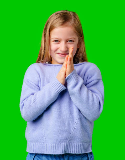 istock A young child in a cozy sweater and blue cargo pants poses with hands clasped 2195209665