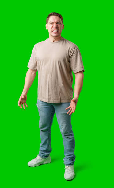 istock Man expressing intense frustration while standing against a bright green background 2195209667