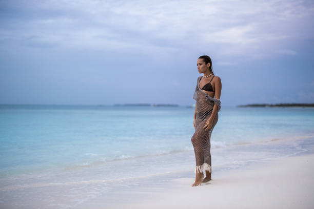 istock Beautiful woman day dreaming on the beach. 2195209687