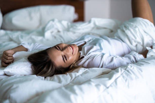 istock Happy woman enjoying while lying in bed. 2195209855