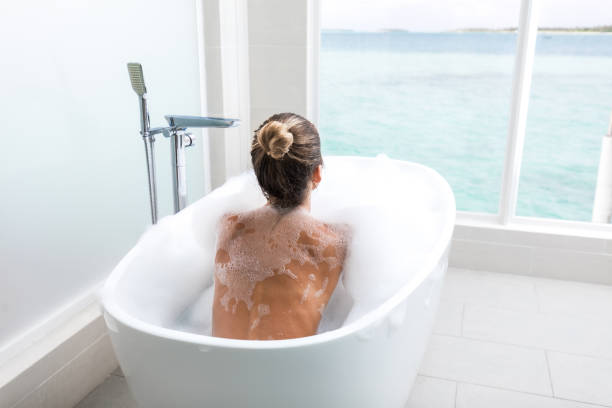 istock Back view of relaxed woman taking a bubble bath. 2195209862