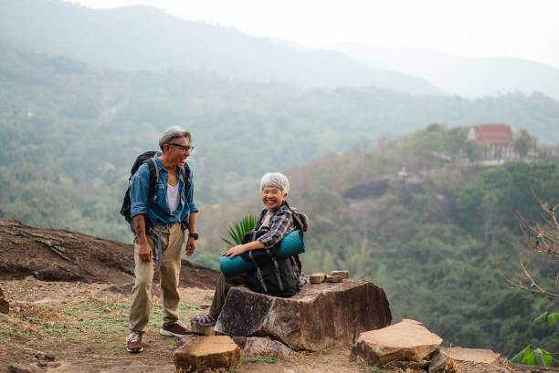 istock Elderly friends are sitting and talking on a mountain with a beautiful view. 2195210326