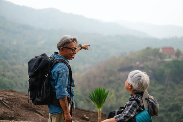 istock Elderly friends are sitting and talking on a mountain with a beautiful view. 2195210327