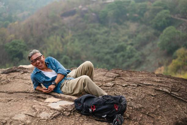 istock An elderly man is chilling on a hillside and enjoying the beautiful view. 2195210342