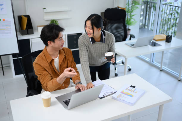 istock Young business team reviewing documents and discussing ideas in a modern office 2195212107