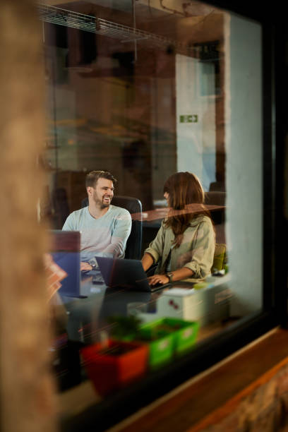 istock Happy freelancers talking while working on laptop in the office. 2195215948