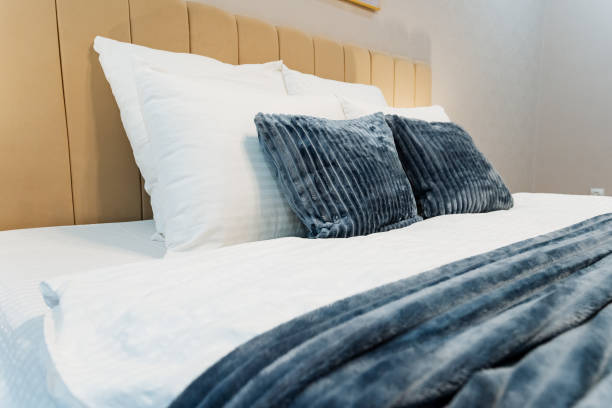 istock A cozy bedroom features a beautifully arranged bed with white sheets and vibrant blue pillows, fostering relaxation and providing ultimate comfort for a peaceful retreat 2195217967