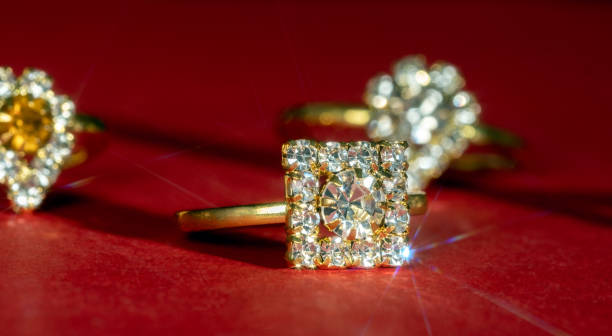 istock Selective focus golden ring with jewels on a red background. 2195219706