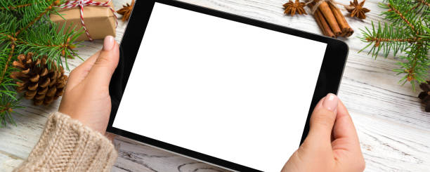 istock woman hands using tablet computer on wooden table bachground. cristmas shopping time. Happy Christmas mock up background, top view 2195222859