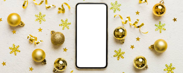 istock Christmas online shopping from home phone with blank white display top view. smart mobile with copy space on colored background with Christmas decorations balls,. Winter holidays sales background 2195222884