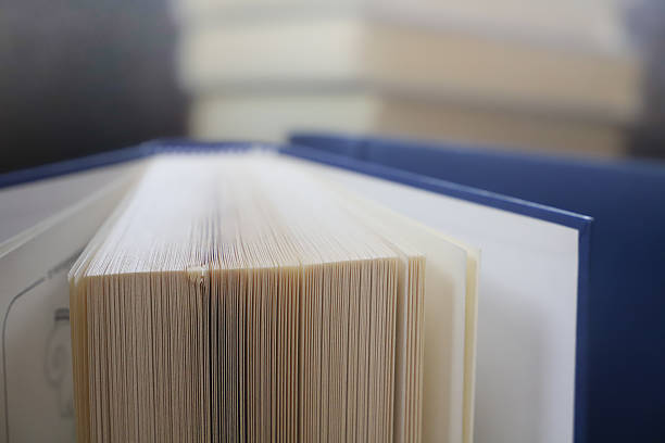 istock stack of books, close up. Open book on the table in library. Back to school concept. 2195223002
