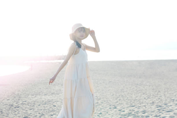 istock Young Asian woman strolling along the beach 2195227634