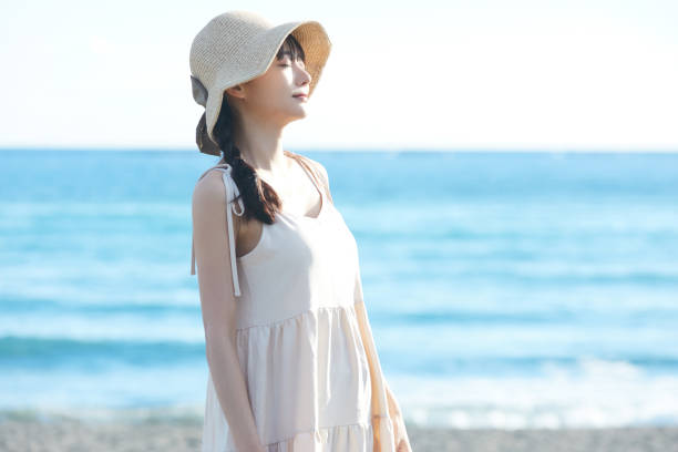 istock Young Asian woman strolling along the beach 2195227692