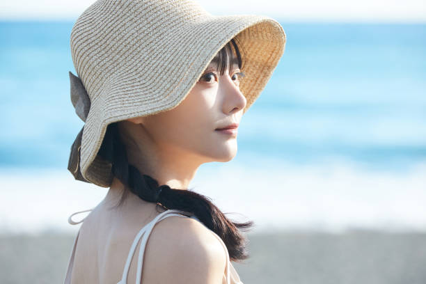 istock Young Asian woman strolling along the beach 2195228009