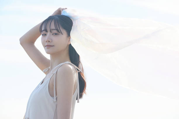 istock Young Asian woman strolling along the beach 2195228299
