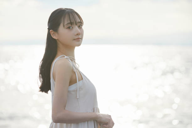 istock Young Asian woman strolling along the beach 2195228686