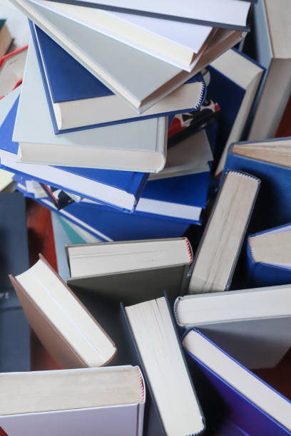 istock stack of books, close up. Open book on the table in library. Back to school concept. 2195229042