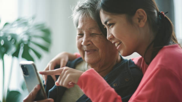 istock Elderly and teen watching on smartphone. 2195230099