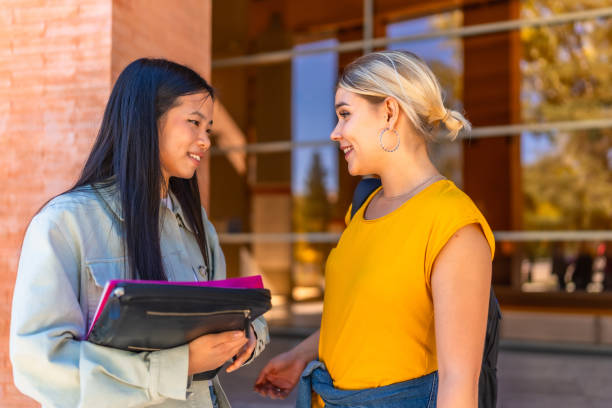 istock Two multi-ethnic students discussing outside the university entrance 2195230882