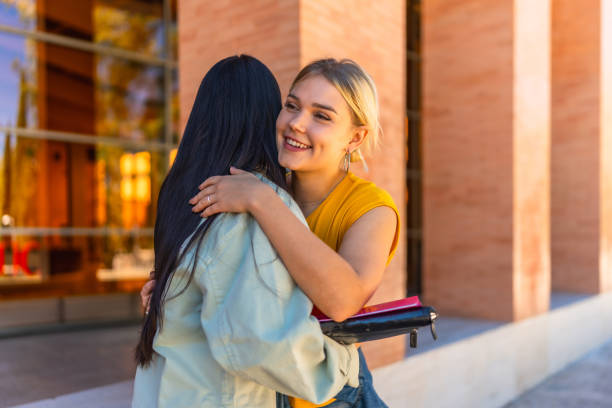 Student greeting a university mate and embracing her