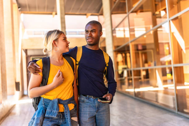 istock Multi-ethnic couple embracing walking along university 2195230939