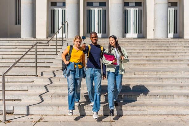istock Students walking down stairs recording online video blog 2195231116