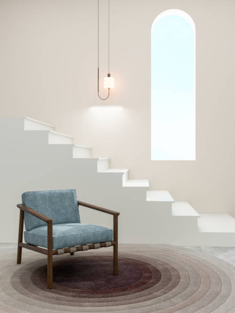 istock A minimalist interior design featuring a modern armchair with a wooden frame and blue upholstery, set on a circular gradient rug, with a floating staircase and a pendant light. 2195231973