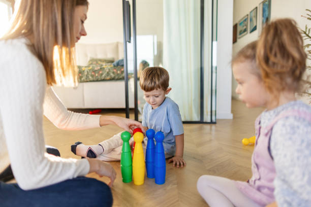 istock Mother and kids playing on the floor 2195233099