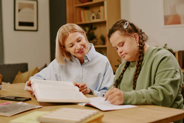 istock Mature Mother Helping Student With Disability With Homework 2195233615