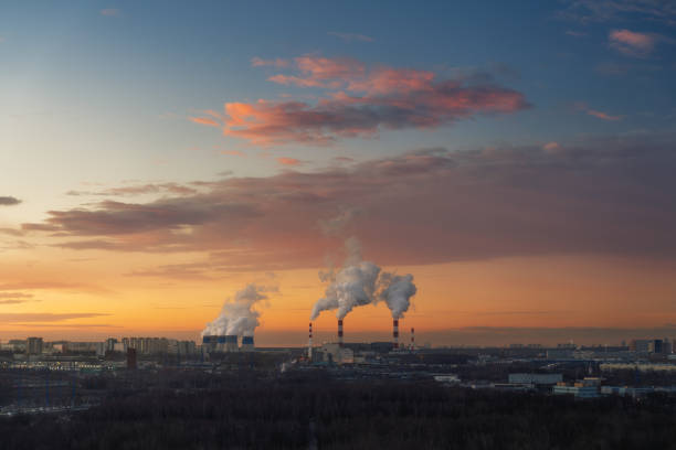 istock Urban Smokestacks Emitting Steam at Winter Sunrise 2195234021