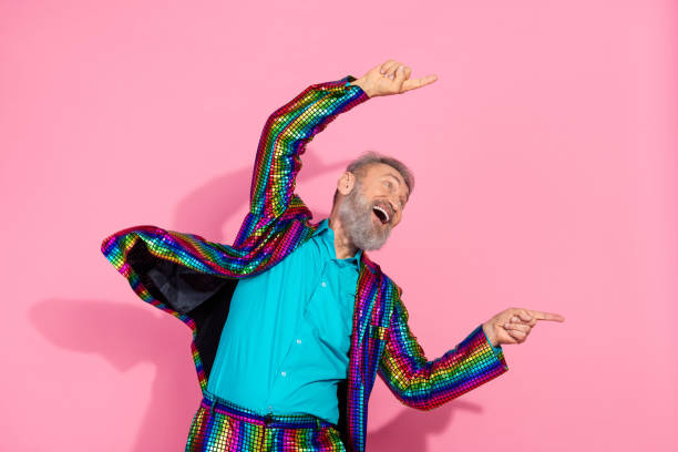istock Energetic Elderly Man in Vibrant Suit Dancing Against a Pink Background 2195235268