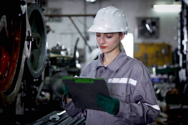 istock Industrial engineer woman with protective workwear and safely helmet check data on document file at manufacturing factory. Beautiful female worker works as inspector at steelmaking metal industry. 2195236268